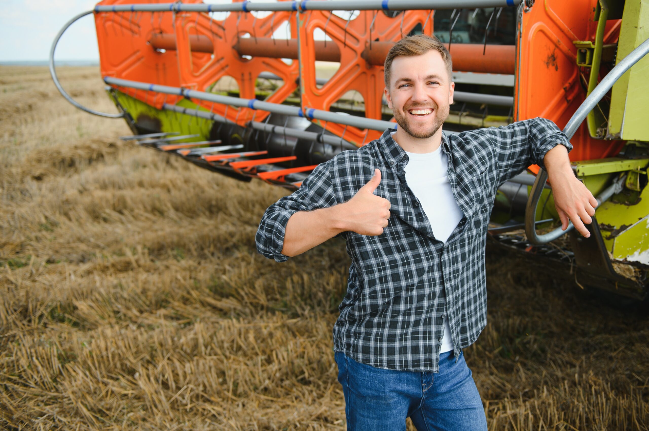 Zufriedener Landwirt vor Mähdrescher